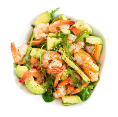 Salad with avocado, shrimp and arugula in white bowl