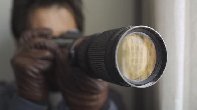 Close up of super secret private detective spying on people and shooting pictures with his camera. 4K