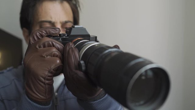 Private detective spying on people and shooting pictures with his camera. 4K