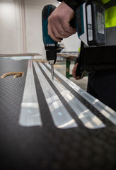 Przykręcanie szyn do podłogi samochodowej.