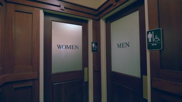 Panning shot of two indoors restroom entrances.