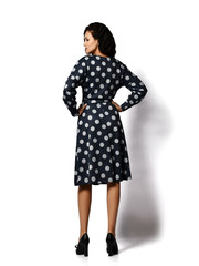 Young beautiful brunette curly smiling woman model in stylish vintage dark dotted midi dress and shoes standing backwards