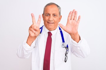 Senior grey-haired doctor man wearing stethoscope standing over isolated white background showing...
