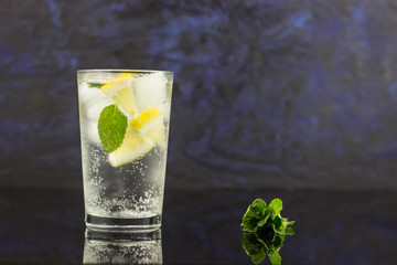 Lemonade with fresh lemon and mint leaves on copy space background