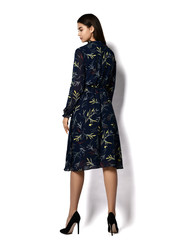 Young beautiful brunette woman with long hair in stylish vintage dark midi dress and high heeled shoes shoes standing backwards