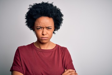 Fototapeta na wymiar Young beautiful African American afro woman with curly hair wearing casual t-shirt standing skeptic and nervous, disapproving expression on face with crossed arms. Negative person.