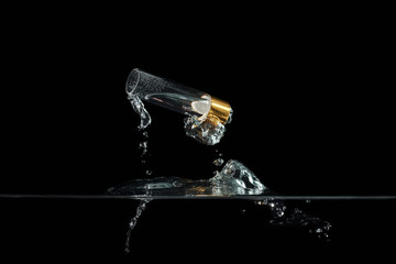 The vial of perfume in a splash in the water