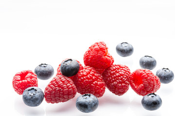 Ripe wild berries on a white background. Garden raspberries. Ripe blueberries. White background. Red. Blue. Isolated.