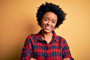 Obraz na płótnie Canvas Young beautiful African American afro woman with curly hair wearing casual shirt happy face smiling with crossed arms looking at the camera. Positive person.