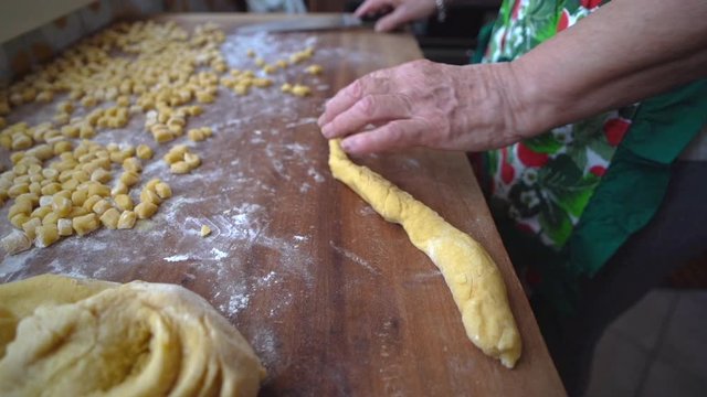 Handmade preparation of struffoli with hand of woman cutting dough