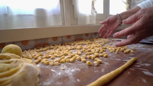 Sift flour from struffoli with hands. Slow motion