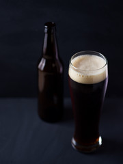 A glass and a bottle of beer on the dark stone table in the bar