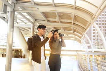 Young Asian tourist couple traveling together. Travelers with backpack and camera explore new...