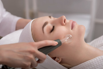 Model geting cleansing peeling rejuvenating facial treatment in a beauty SPA salon.