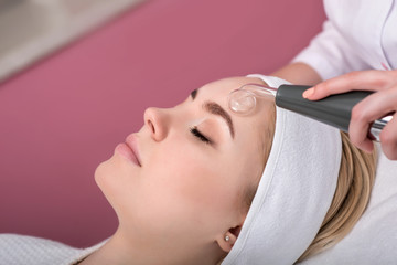 Woman getting cleansing rejuvenating facial treatment in a beauty SPA salon.