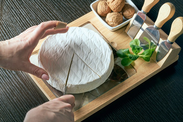 Closeup on woman cutting fresh cheese