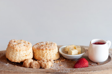 Fresh scones butter and strawberry jam serve on wooden tray, food stylish.