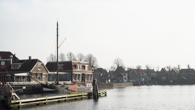 picturesque harbor in a small village in the netherlands with a big sail boat steady shot