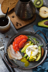 Valentine's day breakfast. Boiled egg sandwich with avocado, coffee, salmon and smoked salmon on a stone concrete tabletop.