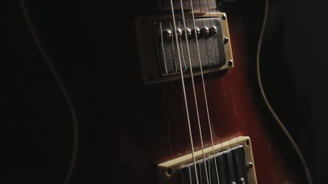 Tilt Down Of Acoustic Guitar From Neck Fingerboard To Bridge - Close Up Shot