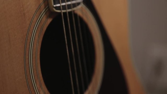 Close Up Of A Soundhole Part Of A Yellow Acoustic Guitar With String - Close Up Shot