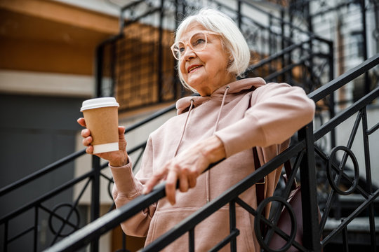 Cheerful seniour woman drinking coffee outdoors stock photo