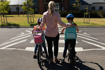 Female teacher with long blonde hair standing on a pedestrian crossing