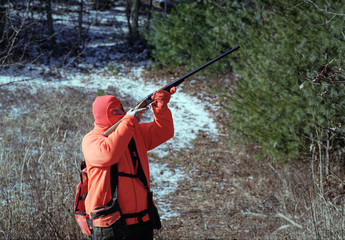 A Hunter Takes Aim At A Bird In A Tree