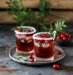 Cranberry cocktail with ice. Christmas cranberry beverage in glasses decorated with sugar and rosemary