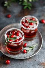 Cranberry cocktail with ice. Christmas cranberry beverage in glasses decorated with sugar and rosemary