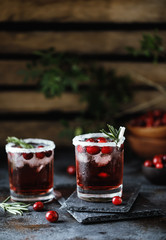 Cranberry cocktail with ice. Christmas cranberry beverage in glasses decorated with sugar and rosemary