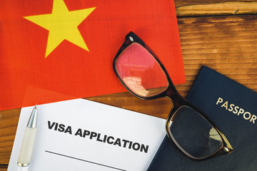 Flag of Vietnam , visa application form and passport on table