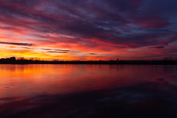 the majestic sunset over the lake. colorful saturated clouds reflected in water. dramatic scene. beautiful landscape. color in nature. beauty in the world