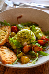 Vegetarian italian food, fresh vegetables salad with white soft burrata cheese and green pesto