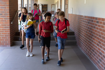 Group of school pupils walking in an outdoor corridor at elementary school