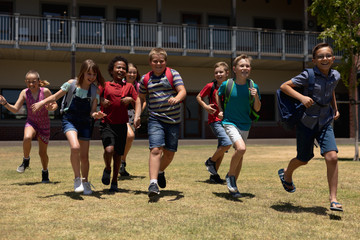 Group of schoolchildren running in a playing at elementary school