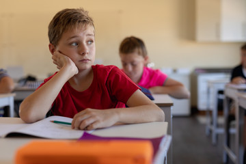 Schoolboy sitting at a desk in an elementary school classroom