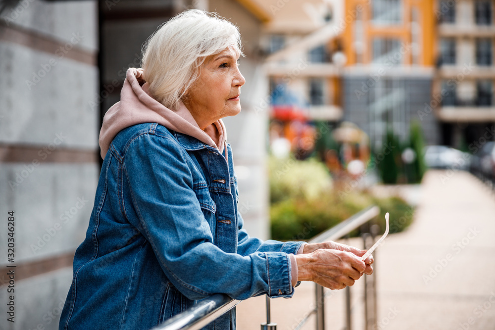 Poster pensive seniour lady in city centre stock photo