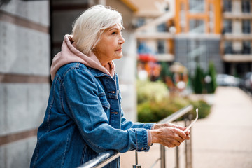 Pensive seniour lady in city centre stock photo