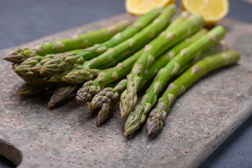 Bunch of fresh green raw organic asparagus with lemon ready to cook