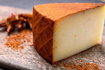 Cheese collection, piece of Spanish manchego cheese made from cow milk with red paprika
