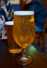 Misty glasses with two pints of cold Scotch ale, pale ale, lager draft beer in English pub