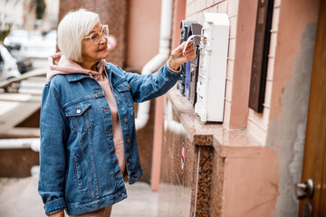 Mature female using mailbox outdoors stock photo