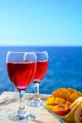 Two glasses with rose wine served outdoor with exotic fruits on tropical island La Palma, Canary islands, Spain with beautiful blue ocean view