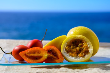 Fresh ripe yellow  passion fruit and tamarillo on blue sea background