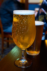 Misty glasses with two pints of cold Scotch ale, pale ale, lager draft beer in English pub
