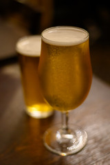 Misty glasses with two pints of cold Scotch ale, pale ale, lager draft beer in English pub