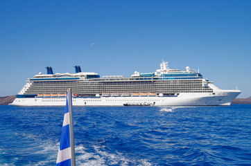 Luxury cruise ship liner or cruiseship anchoring in bay at sea in front of Greek Island during...