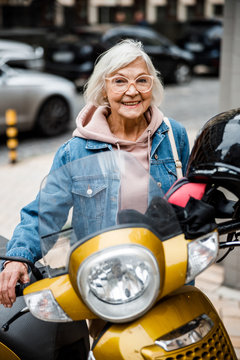 Jolly Elderly Female With Motorbike Stock Photo