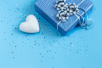 Gift box Packed in blue paper on a blue background .